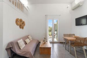 a living room with a couch and a table at LausAndros Suites in Andros