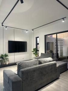 a living room with a couch and a flat screen tv at The Perch House in Silañgang Mayao