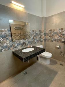 a bathroom with a sink and a toilet at Vistara courtyard in Varanasi