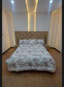a bedroom with a large bed with a large headboard at dukan nahwi in Ursē