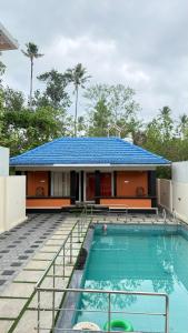 a house with a swimming pool in front of a house at The Royal Pool Resort-Swimming Pool Resort, Varkala in Varkala