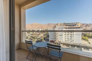 a balcony with a table and chairs and a view at Lacosta Hotel in Aqaba