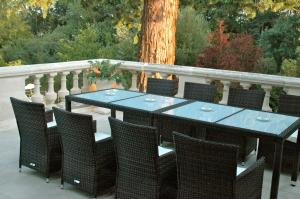 une table bleue et des chaises sur un balcon avec un arbre dans l'établissement La Grande Maison, à Pas-de-Jeu