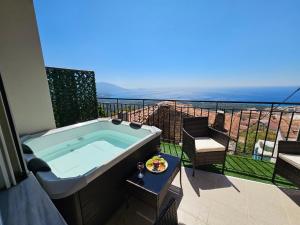 a hot tub on a balcony with a view of the ocean at Casa Nevina in Marathokampos