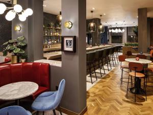a restaurant with tables and chairs and a bar at ibis Styles Edinburgh St Andrew Square in Edinburgh