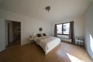 a white bedroom with a bed and a window at Spacious Apartment at Top Location Grote Markt in Sint-Niklaas
