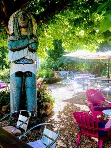 a statue in a garden with chairs and tables at Chez Mikki in Cassaniouze