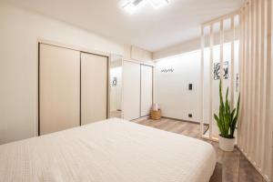 a bedroom with a white bed and a plant at Corfu nest apartment in Ágios Rókkos
