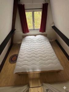 a bed in a small room with a window at Boshuis Green Forest in Durbuy