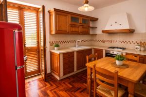 a kitchen with wooden cabinets and a wooden table at Aloha Village - Bed&Pet in Messina +11 photos