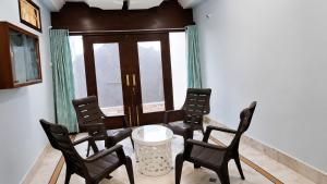 a room with chairs and a table and a window at Moti Manas Mansion - A Homestay in Gwalior in Gwalior