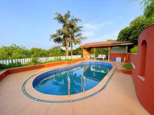 a swimming pool in the middle of a yard at Ramsukh Resorts and Spa in Mahabaleshwar