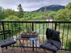 a table and two chairs on a balcony with a view at Vulcanus Apartment in Badacsonytomaj