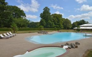 a large swimming pool with lounge chairs around it at B&B Domaine de La Corbe in Bournezeau