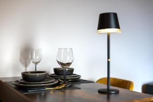 a table with two wine glasses and a lamp at Osé in Chênet +2 photos
