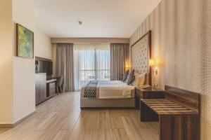 a hotel room with a bed and a desk at Lacosta Hotel in Aqaba +119 photos