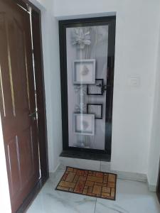 a hallway with a door and a mirror and a rug at Grace villa Homestay in Vattavada