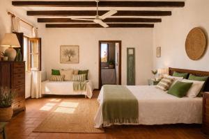 a bedroom with two beds and a ceiling fan at Monte da Lagoa in Altura