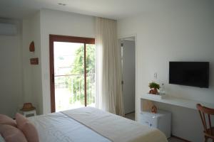 a bedroom with a bed and a large window at Casa Aia - Hospedagem de Charme na Atalaia in Aracaju