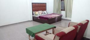 a bedroom with a bed and a table and chairs at The Dream Hotel And Rooms in Etāwah