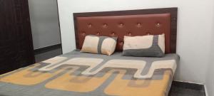 a bedroom with a bed with a brown headboard and pillows at The Dream Hotel And Rooms in Etāwah +5 photos
