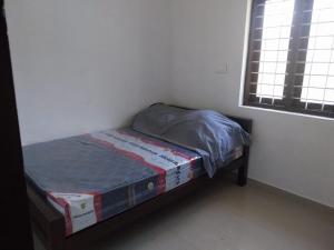 a small bed in a room with a window at Grace villa Homestay in Vattavada