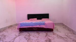 a bedroom with a bed with a pink blanket on it at The Dream Hotel And Rooms in Etāwah