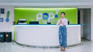 a woman standing in front of a counter in a room at POP! Hotel Kuta Beach in Kuta