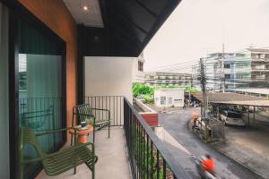 a balcony with two green chairs on a building at Easterly Room 01 in Chanthaburi