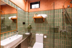 a bathroom with a toilet and a sink and a mirror at Easterly Room 01 in Chanthaburi