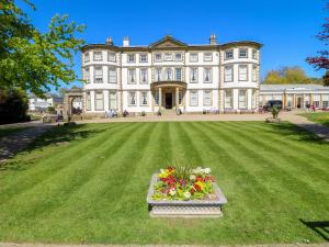a large house with a large lawn with flowers in front at Apt 5 Hunter's Quay in Bridlington