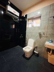 a bathroom with a toilet and a sink at Rosewood Camellia - Near Ooty Town in Ooty