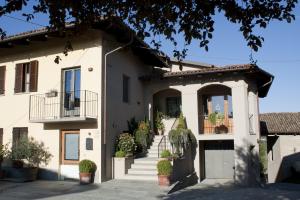 a large white house with stairs and potted plants at Agriturismo Rivella in Barbaresco