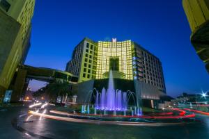 a building with a fountain in the middle of a street at Grand Millennium Muscat Apartments and Suites connected to Mall in Muscat