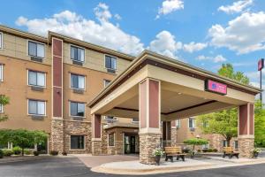 a hotel with a gas station with two benches at Comfort Suites Grand Rapids North in Comstock Park