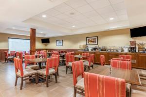 a restaurant with tables and chairs and a bar at Comfort Suites Grand Rapids North in Comstock Park