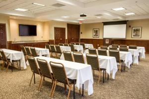 a conference room with white tables and chairs and a screen at Comfort Suites Grand Rapids North in Comstock Park +24 photos