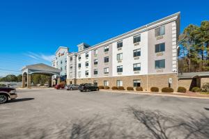 a large building with cars parked in a parking lot at Comfort Suites Sanford in Sanford