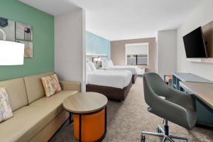 a hotel room with two beds and a couch at Comfort Suites Sanford in Sanford