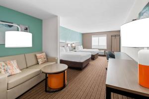 a hotel room with a couch and two beds at Comfort Suites Sanford in Sanford +30 photos