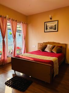 a bedroom with a bed with red sheets and a window at Rosewood Camellia - Near Ooty Town in Ooty