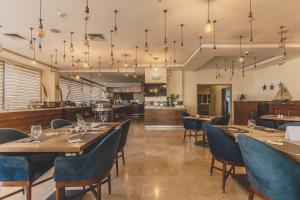 a restaurant with wooden tables and blue chairs at Lacosta Hotel in Aqaba