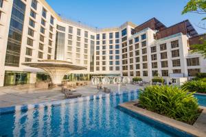 an exterior view of a hotel with a swimming pool at Grand Millennium Muscat Apartments and Suites connected to Mall in Muscat