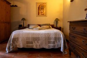 a bedroom with a bed and a dresser at Bastide Du Maoupas Gîtes in Belgentier