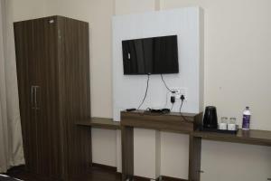 a room with a tv on a wall with a table at Doon Sanskaram Hotel in Chūharpur