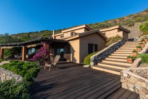 a house with a wooden deck and stairs at Fantastica Villa con piscina e vista mare in Alghero