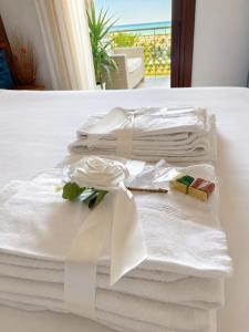 a pile of white towels sitting on a bed at Sea Colors Apartment in Montesilvano