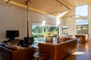 a living room with couches and chairs and a television at The Dunes Pringle Bay in Pringle Bay