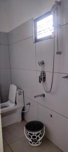 a bathroom with a shower and a toilet and a bucket at Kanchan Grace in Vaduvanchal
