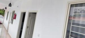 a white building with two doors and a window at Kanchan Grace in Vaduvanchal